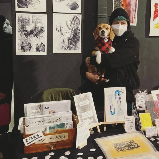 Lex with their dog Ragis at an art event